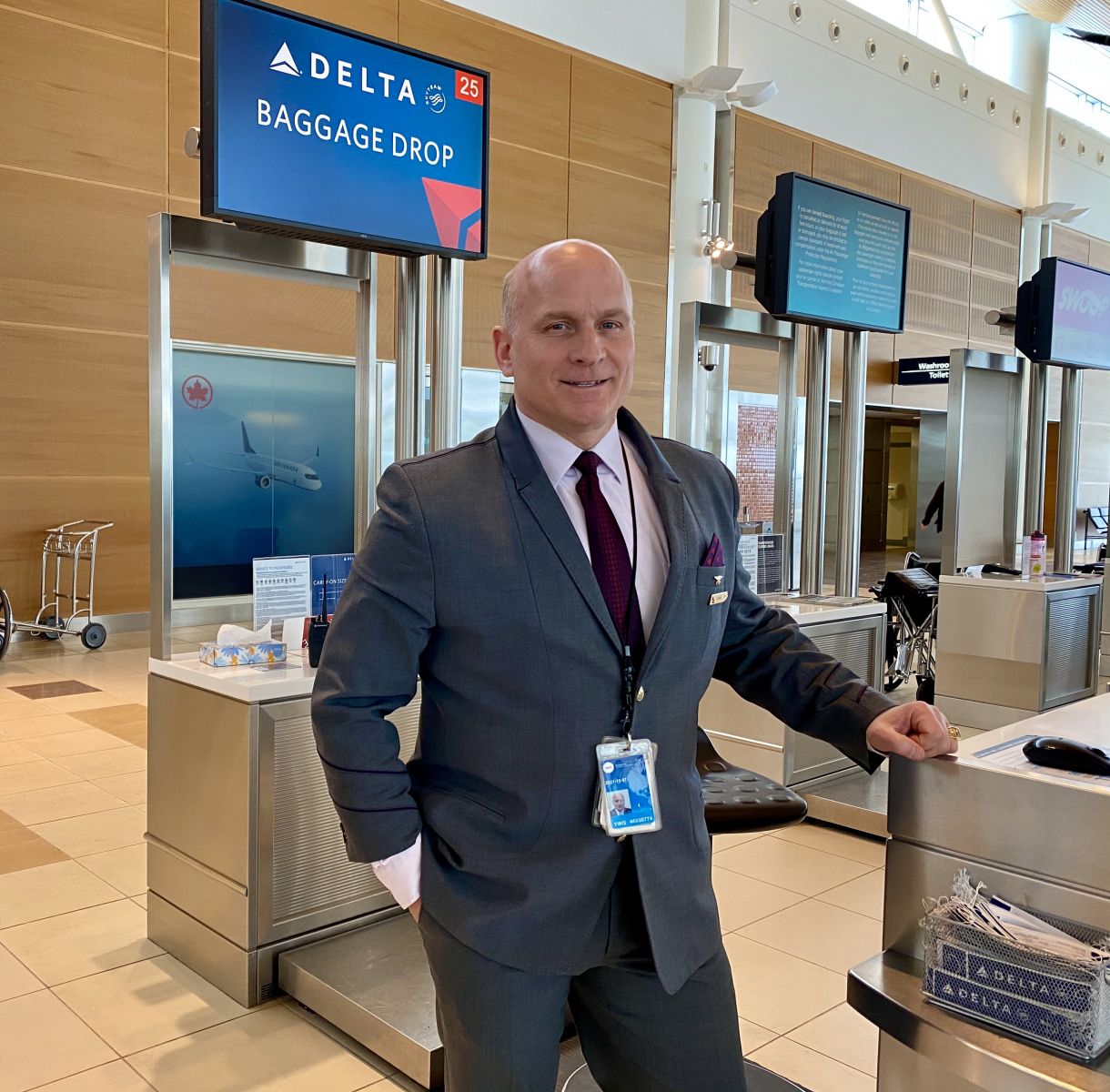 Delta Service Agent Jeff McWhinney standing at the airline check-in counter