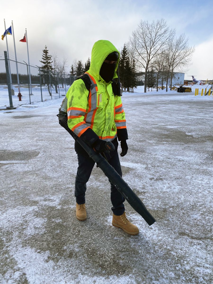 Employee blowing snow on the airfield to keep the surface clear