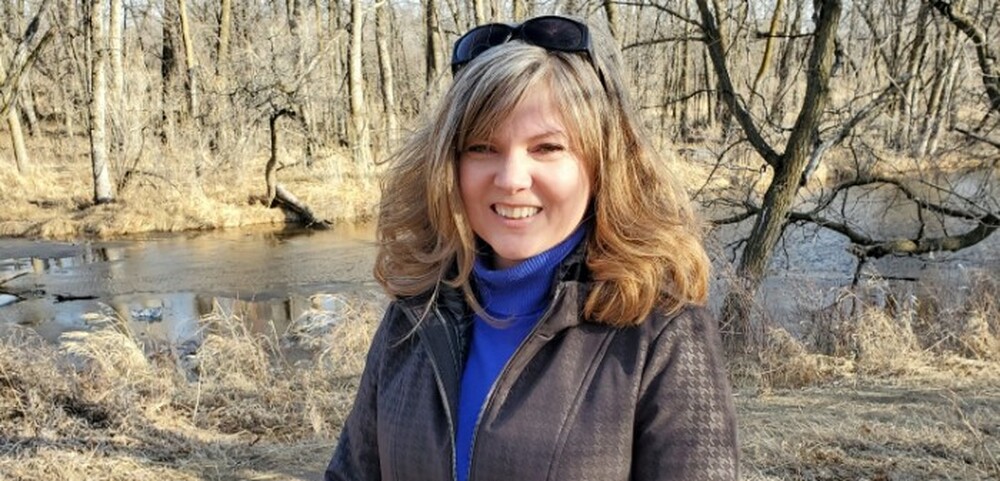 Environmental specialist outside on the airport campus next to a tributary of the Assiniboine River